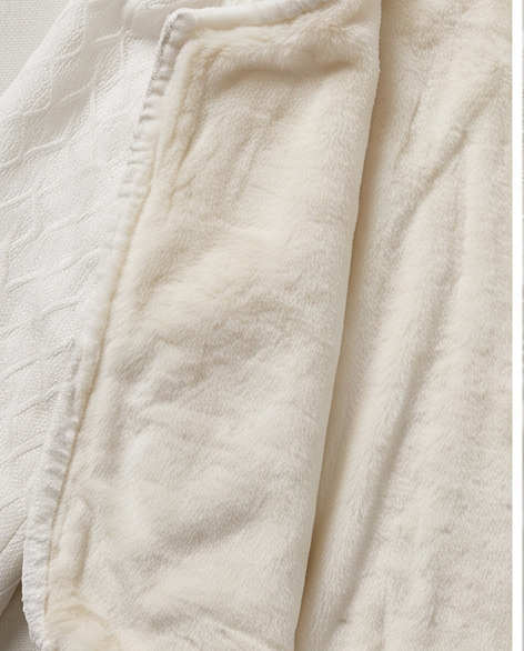White communion jacket flat lay showing velvet lining interior and textured knit exterior