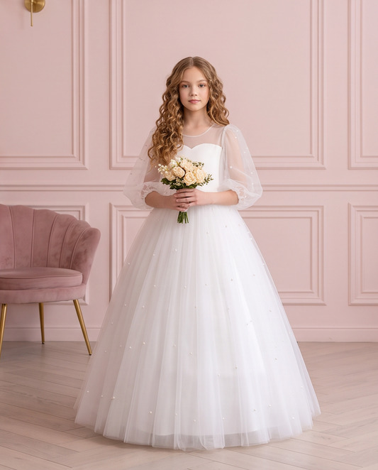 Front view of the Pearl Reverie white communion dress, worn by a girl holding a bouquet.