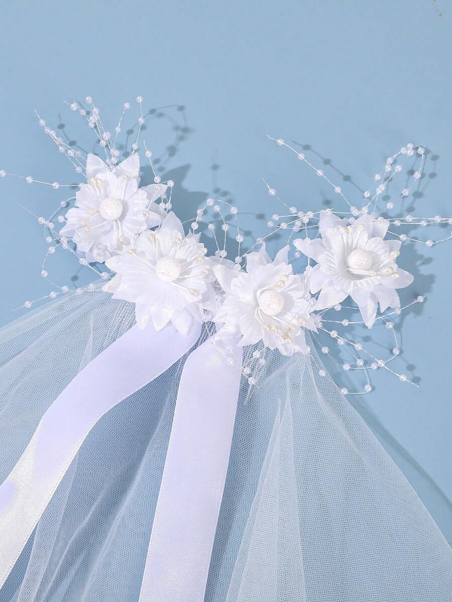 White floral comb communion veil with pearl sprays and satin ribbon, close-up of flower and pearl detail