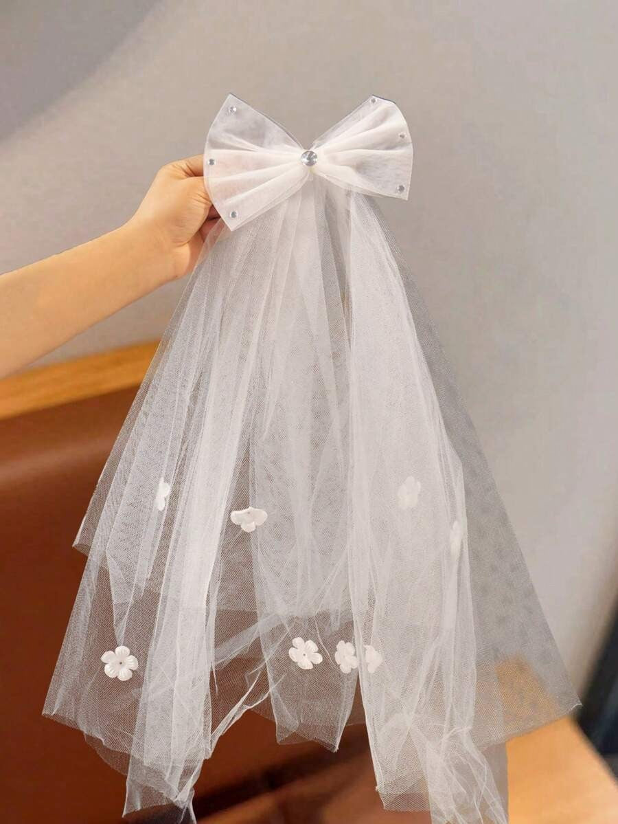 White tulle bow communion veil with floral appliqués held up showing full length and large organza bow detail