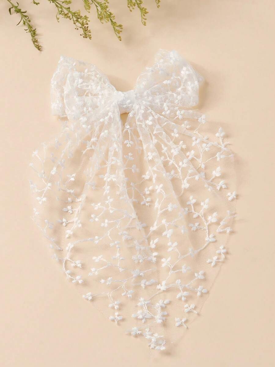 White lace veil with floral details on a beige background