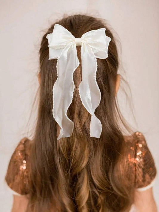 Long hair with a large white bow on a plain background
