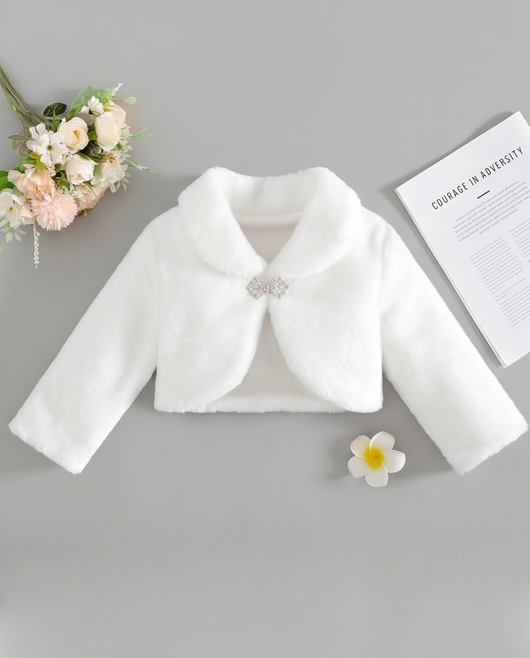 White children's jacket with a brooch on a gray background