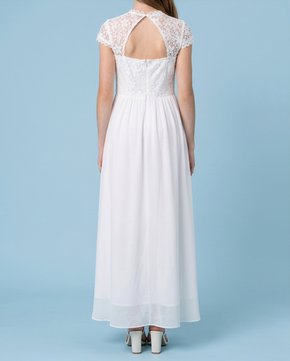 A woman viewed from the back wearing a white maxi dress with a lace open-back neckline, cap sleeves, and a flowing skirt, standing against a light blue studio background.
