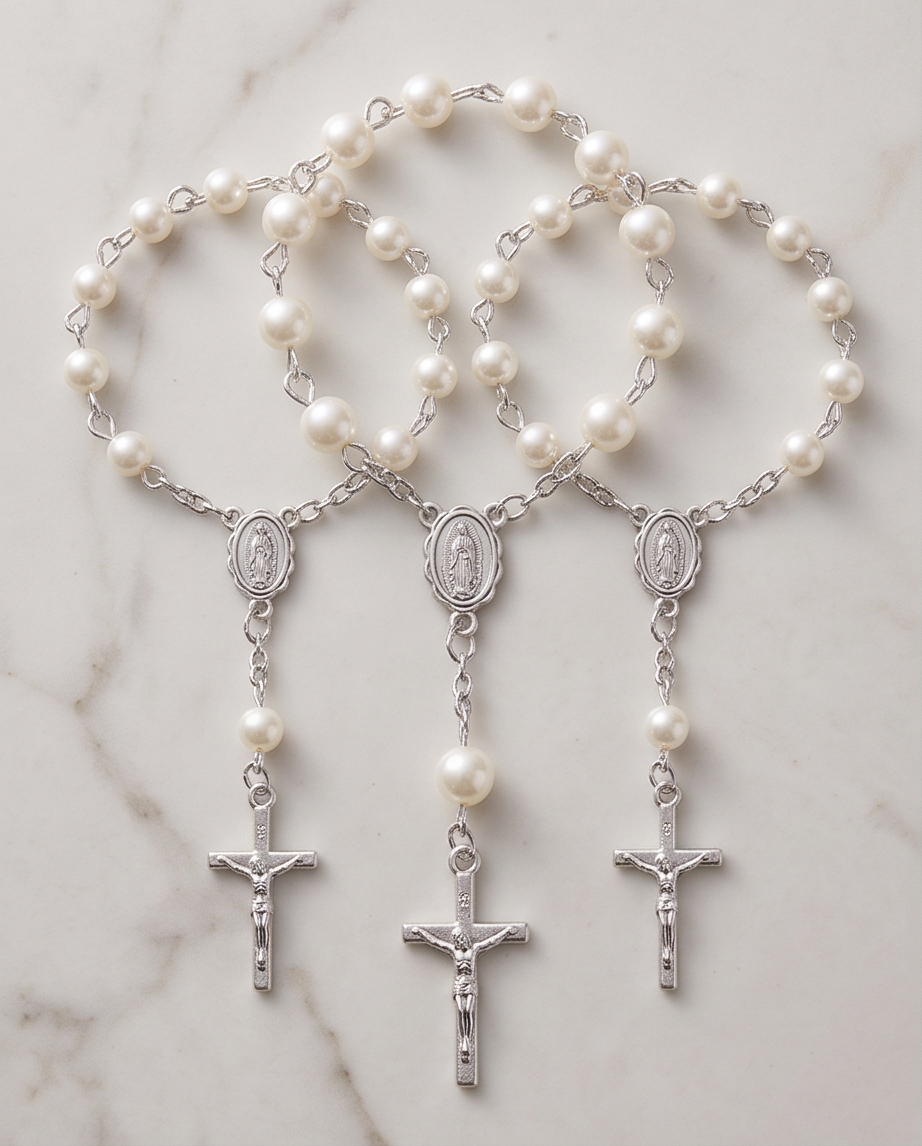 Hand holding white pearl rosary bracelet with silver Miraculous Medal and crucifix, close-up view