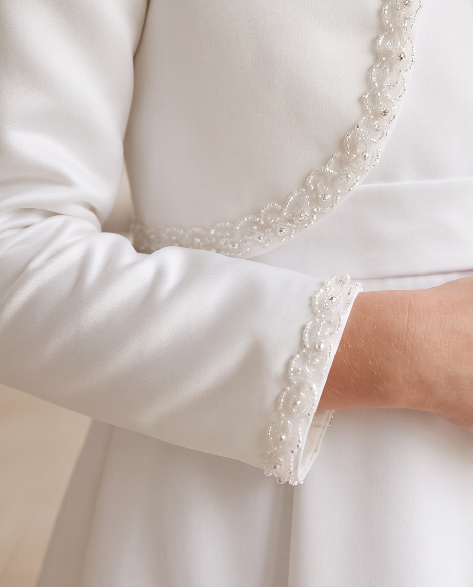 Close-up of pearl and lace trim on white satin bolero jacket