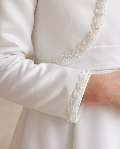 Close-up of pearl and lace trim on white satin bolero jacket