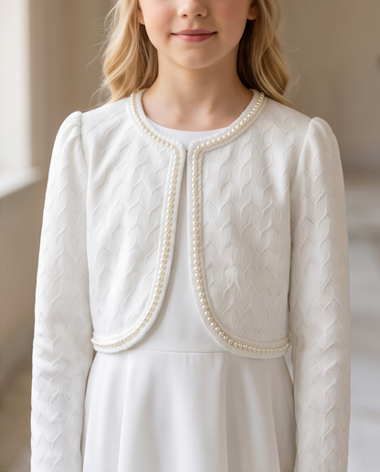 Close-up of pearl trim along front opening of white textured knit communion jacket showing fabric texture detail