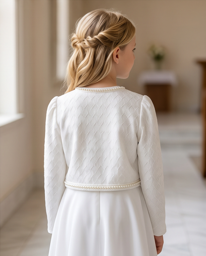 Close-up of white textured knit fabric with pearl trim on communion jacket sleeve cuff