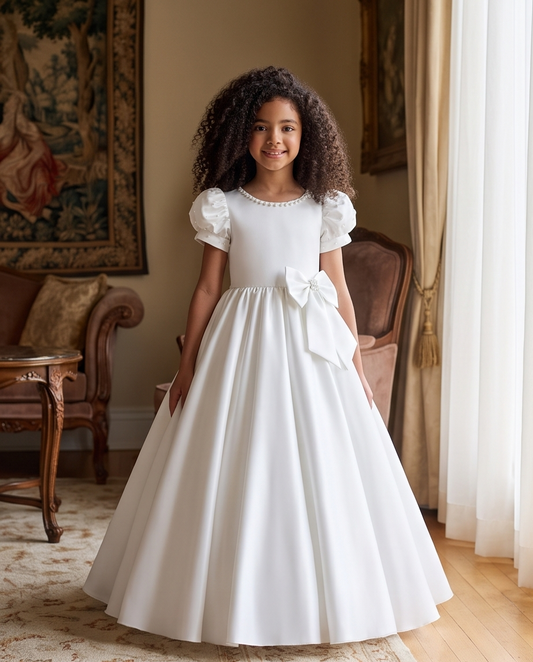 Girl wearing white satin communion dress back view with veil