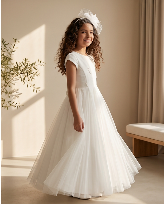 Close-up of pearl button back closure on white communion dress