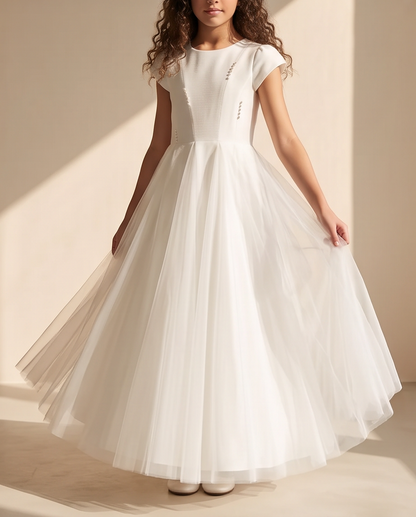 Girl wearing white pearl detail communion dress with tulle skirt twirling full length view
