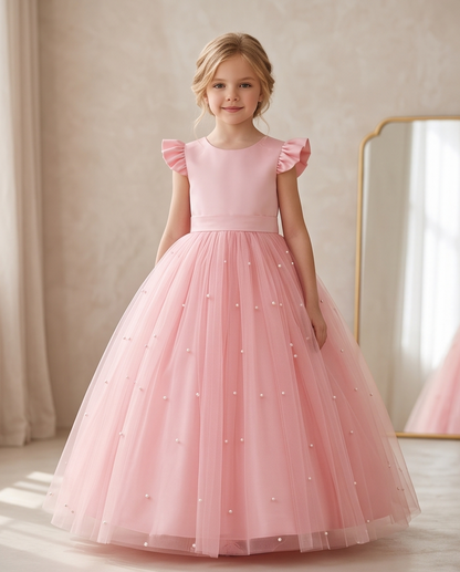 Girl wearing pink pearl tulle flower girl dress smiling front view