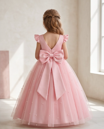 Girl wearing pink pearl tulle flower girl dress back view showing V-back and satin bow