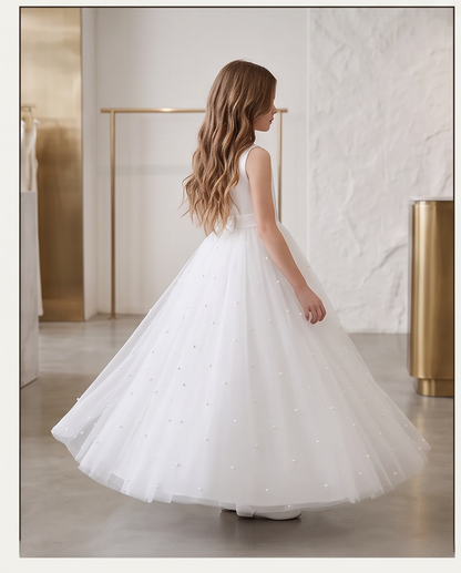 Back view of white pearl tulle dress showing V-back and large satin bow