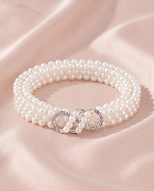 White pearl-look infinity clasp communion belt on soft pink fabric