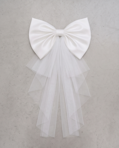 Oversized white bow with tulle styled on the back of a formal dress