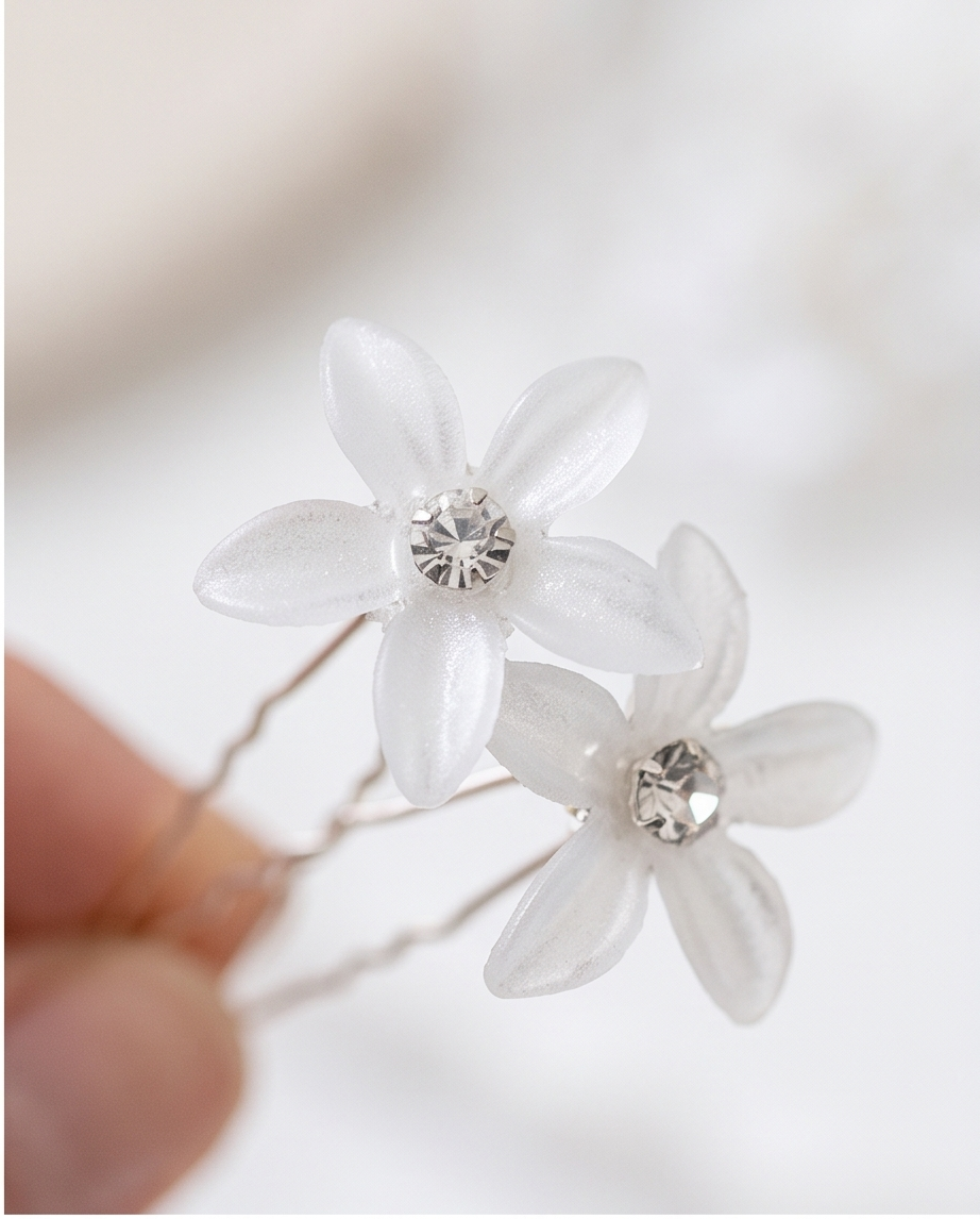Close-up of white flower hair pins and crystal-look centres
