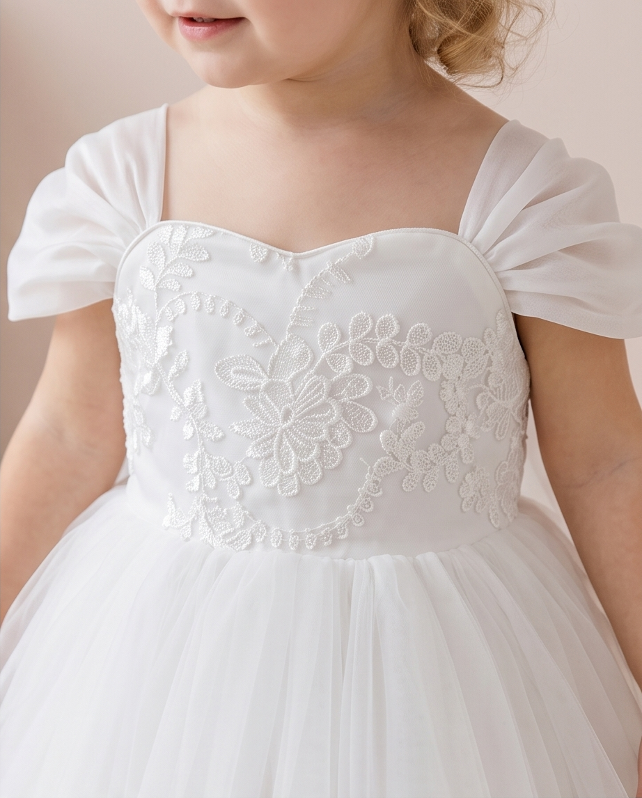 Floral embroidery detail on white dress bodice