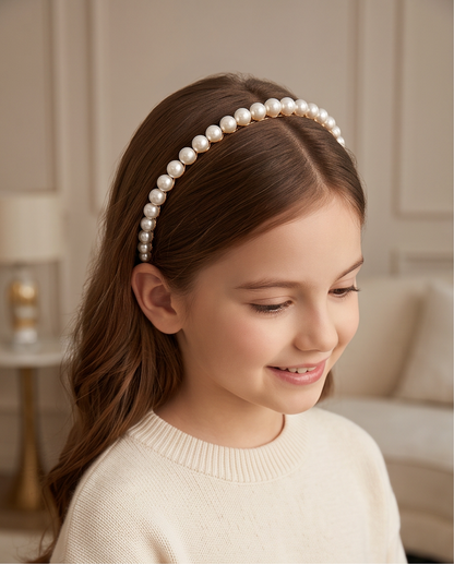 Close-up of a gold-tone twisted headband decorated with mixed-size pearl-look beads.