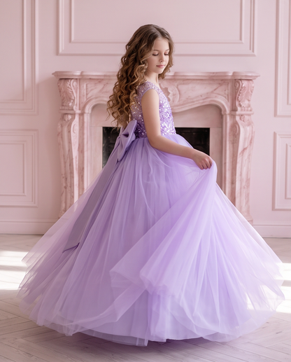 Rear three-quarter view of the Lavender Dreams lavender tulle dress beside a fireplace.