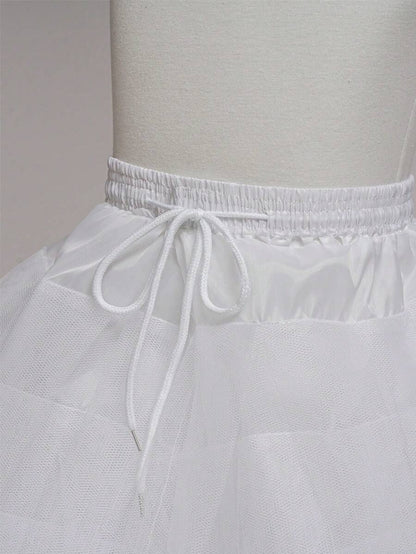 White petticoat on a mannequin against a plain background