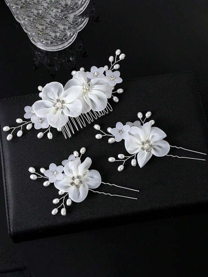 White organza flower hair comb and 2 hair pins with rhinestone centres and pearl spray branches on black background