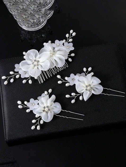 White organza flower hair comb and 2 hair pins with rhinestone centres and pearl spray branches on black background