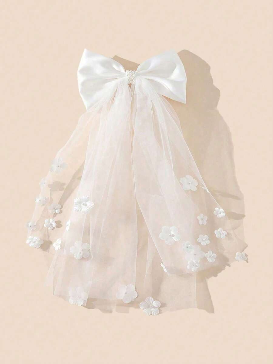 White satin bow communion veil with 3D flower appliqués on tulle, full view on cream background