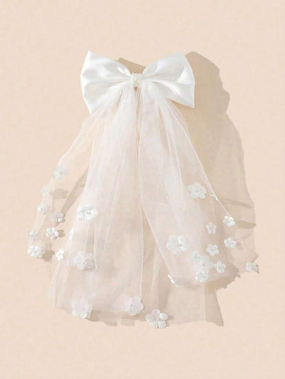 White satin bow communion veil with 3D flower appliqués on tulle, full view on cream background