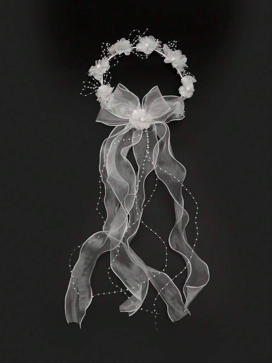 White floral crown communion veil with organza bow and pearl ribbon trails on black background