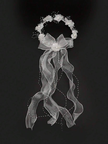White floral crown communion veil with organza bow and pearl ribbon trails on black background