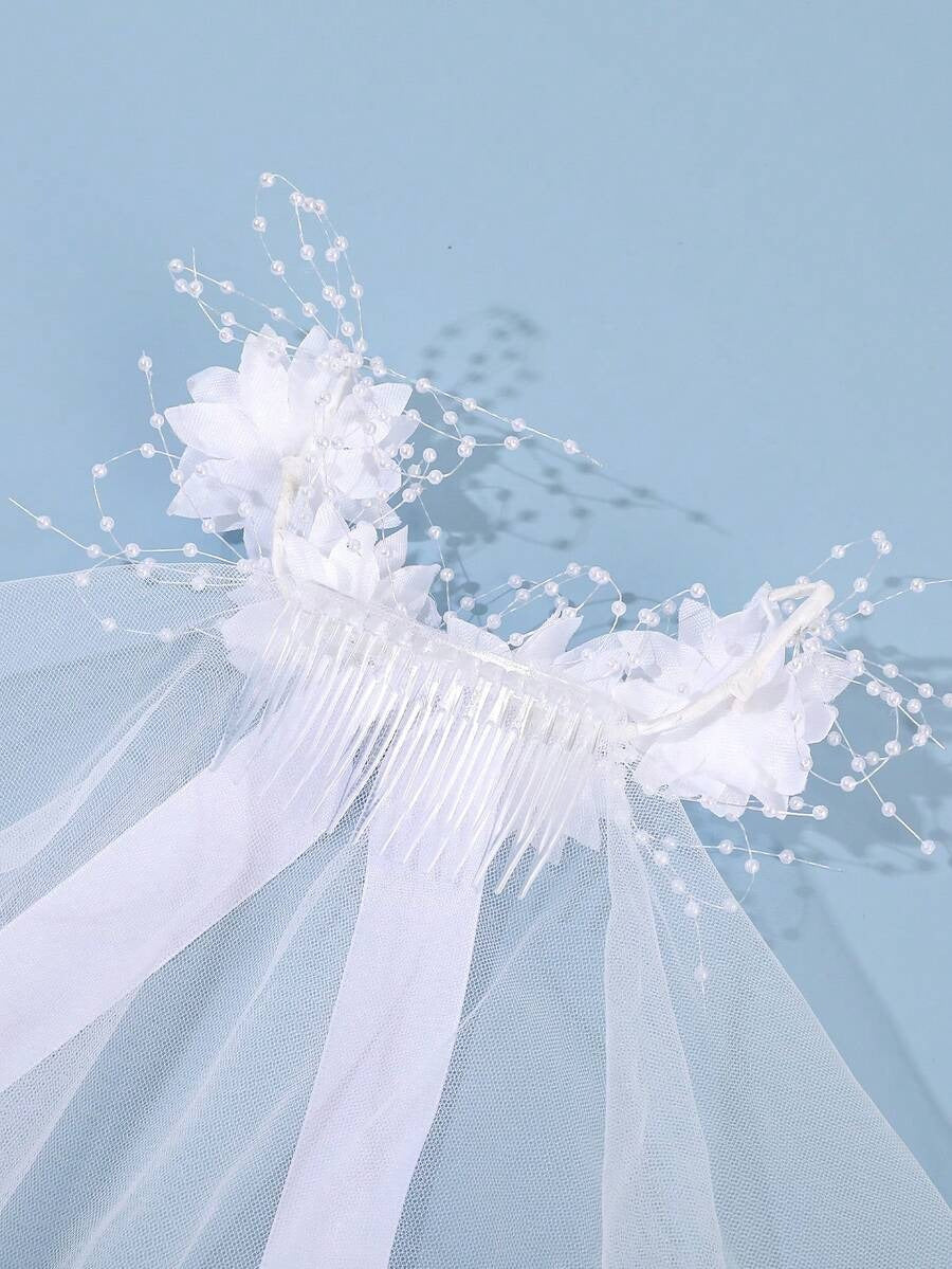 Close-up of white floral comb with pearl spray detail on communion veil