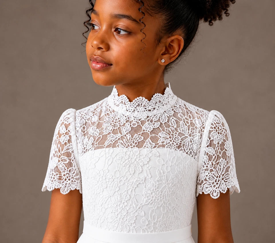 Young girl wearing a white lace dress against a brown background