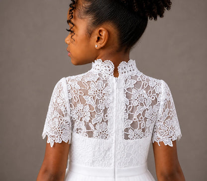 White lace dress worn by a person on a brown background