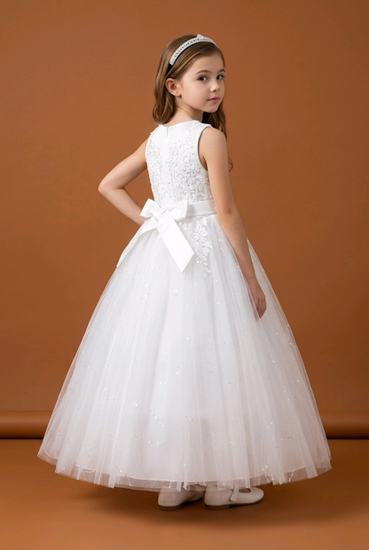 Young girl wearing a white dress with a bow on a brown background