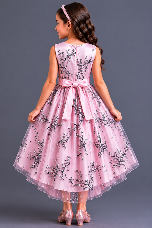 Young girl wearing a pink floral dress against a gray background