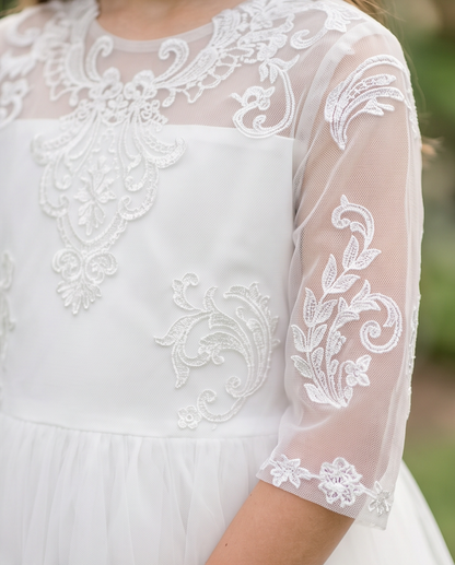 White lace dress with intricate patterns on a blurred natural background