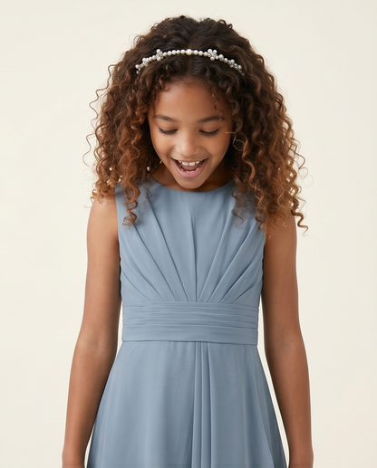 Young girl wearing a light blue dress with a plain background