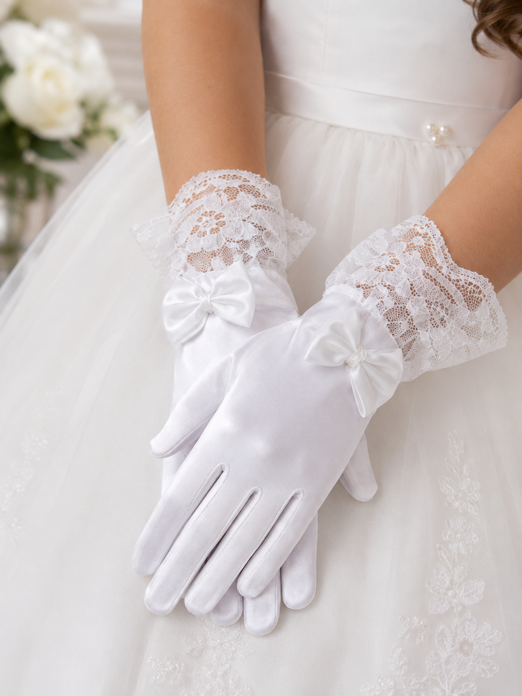 White lace gloves worn with a white dress, blurred floral background