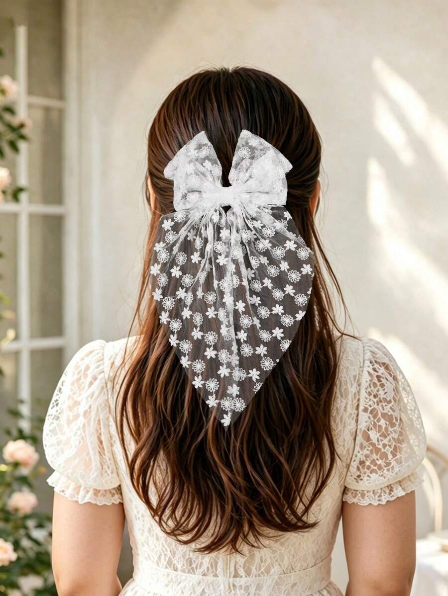 Person with long hair wearing a decorative hair scrunchie in a softly lit room.