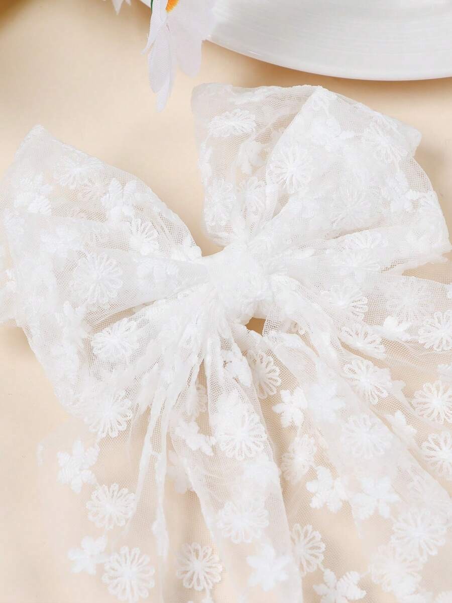 Close-up of a white lace bow on a beige background