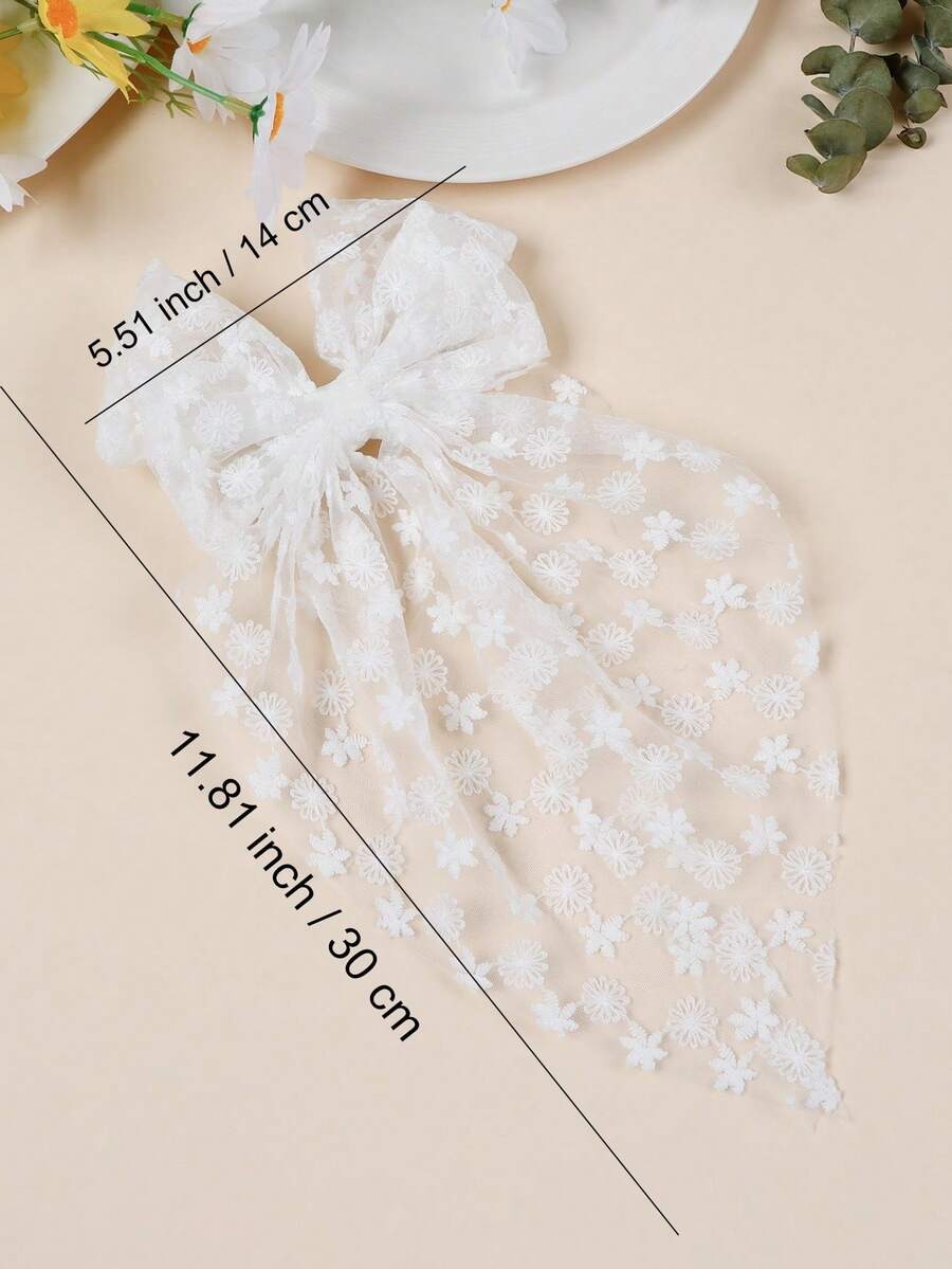 White lace fabric with floral embroidery and measurements on a beige background