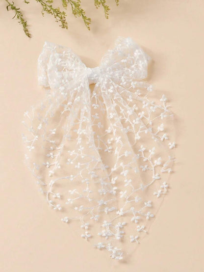 White lace veil with floral details on a beige background