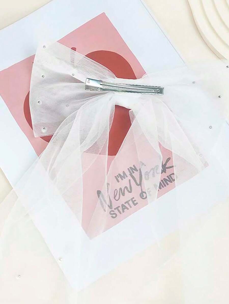 White hair bow with a pink card and text on a white background