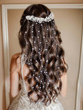Woman with wavy hair wearing a pearl headband and hair extensions.