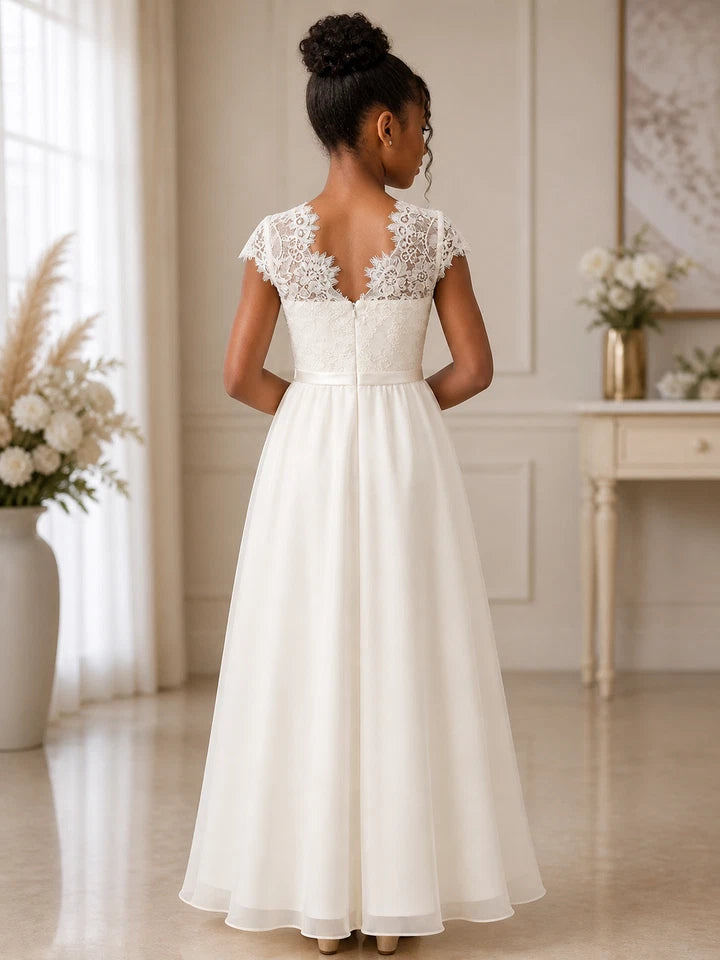 Woman wearing a white wedding dress with lace details in a elegant room.