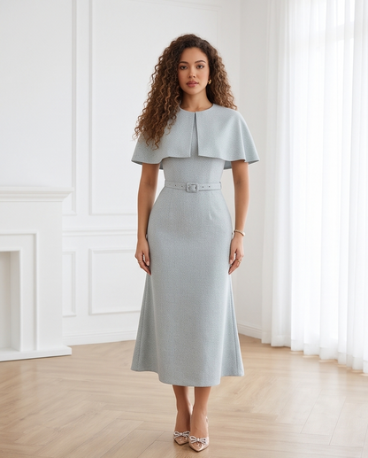 Women’s dusty blue midi dress with a cape-style shoulder overlay, matching buckle belt and gently flared skirt