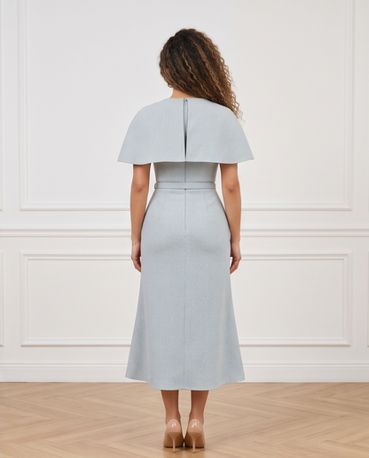 Women’s dusty blue midi dress with a cape-style shoulder overlay, matching buckle belt and gently flared skirt