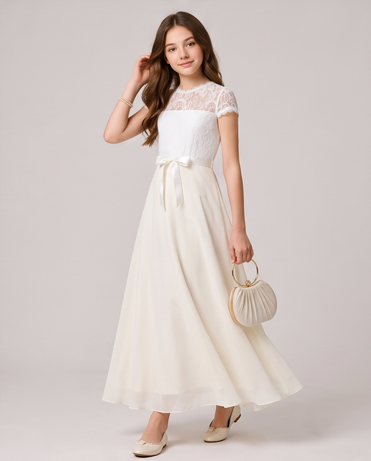 A woman modeling a white lace and chiffon maxi dress with a matching waist tie, holding a small pleated cream handbag against a light gray studio background.